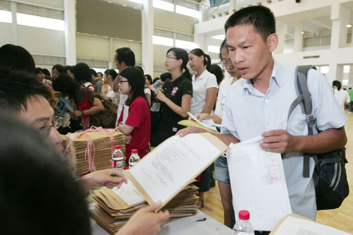 在報(bào)到現(xiàn)場(chǎng)，蔡偉從工作人員手中接過(guò)新生報(bào)到材料。  劉暢/攝 